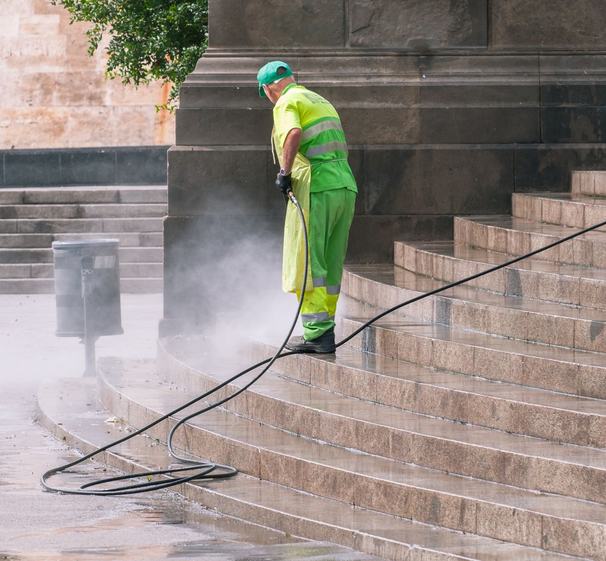 Illustrative photo: technician pressure washing paved surfaces