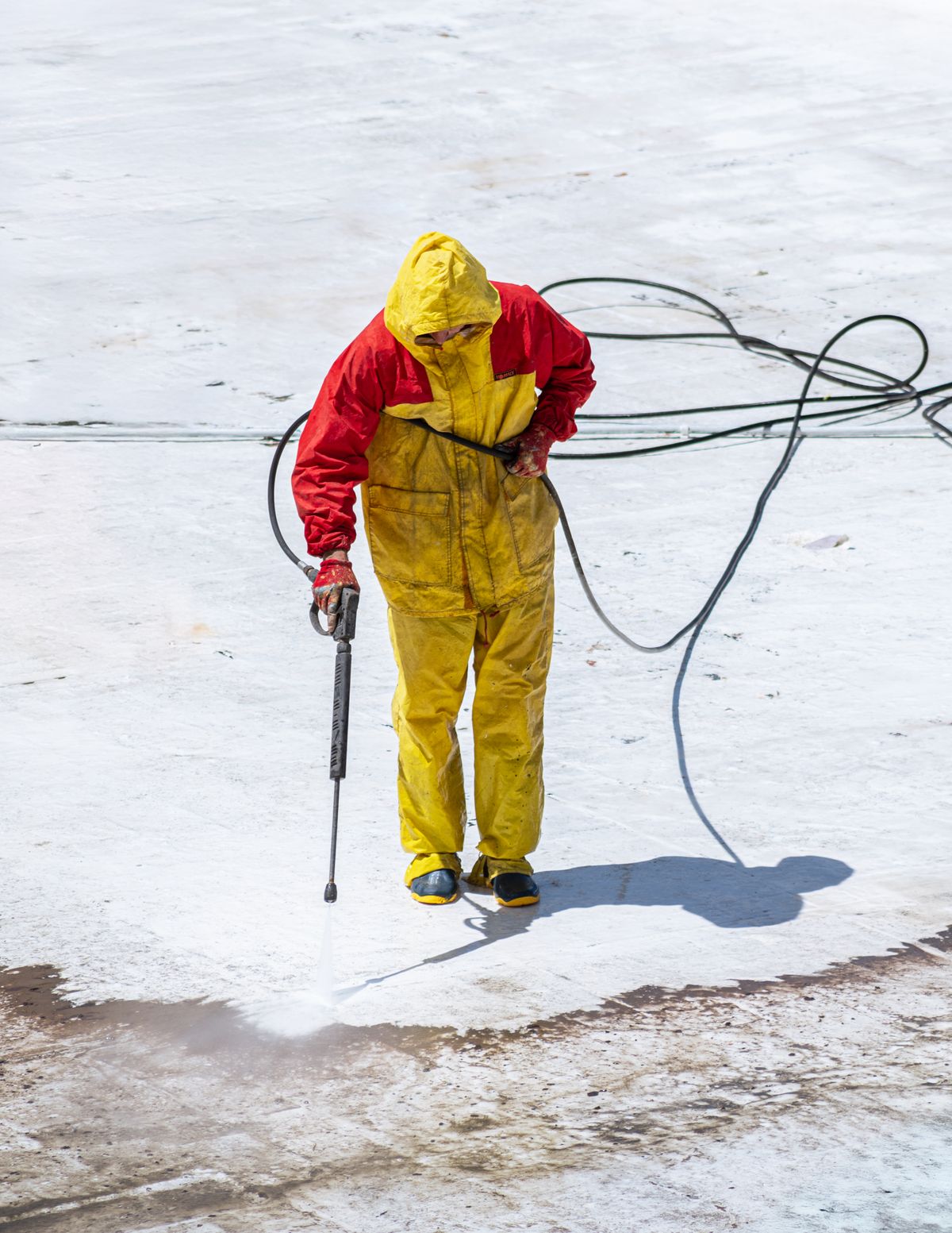 Illustrative photo: technician soft washing an exterior surface